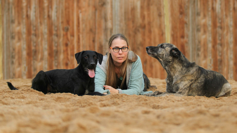 Sabine Ehrhardt, Hundetrainerin und Gründerin von Picocoaching posiert mit ihren beiden Hunden auf dem Boden