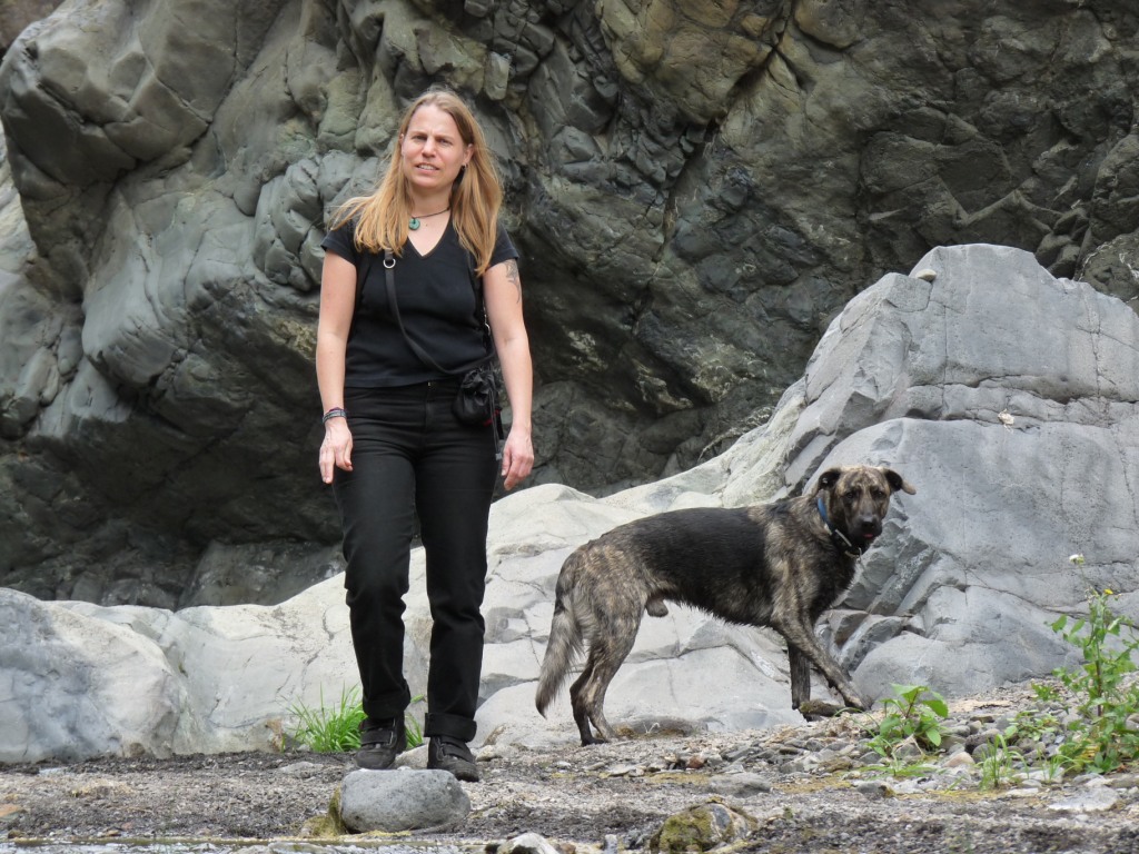 Sabine Ehrhardt, Hundetrainerin und Gründerin von Picocoaching zusammen mit einem ihrer Hunde vor einer Felswand